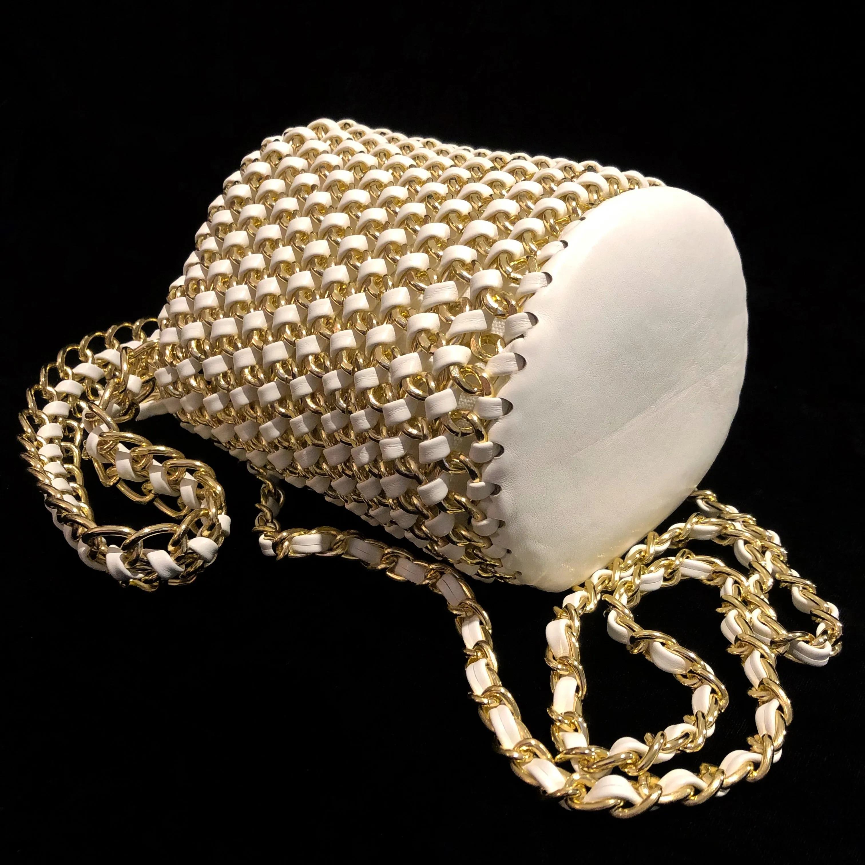A WOVEN WHITE PVC AND GILT CHAIN BUCKET BAG