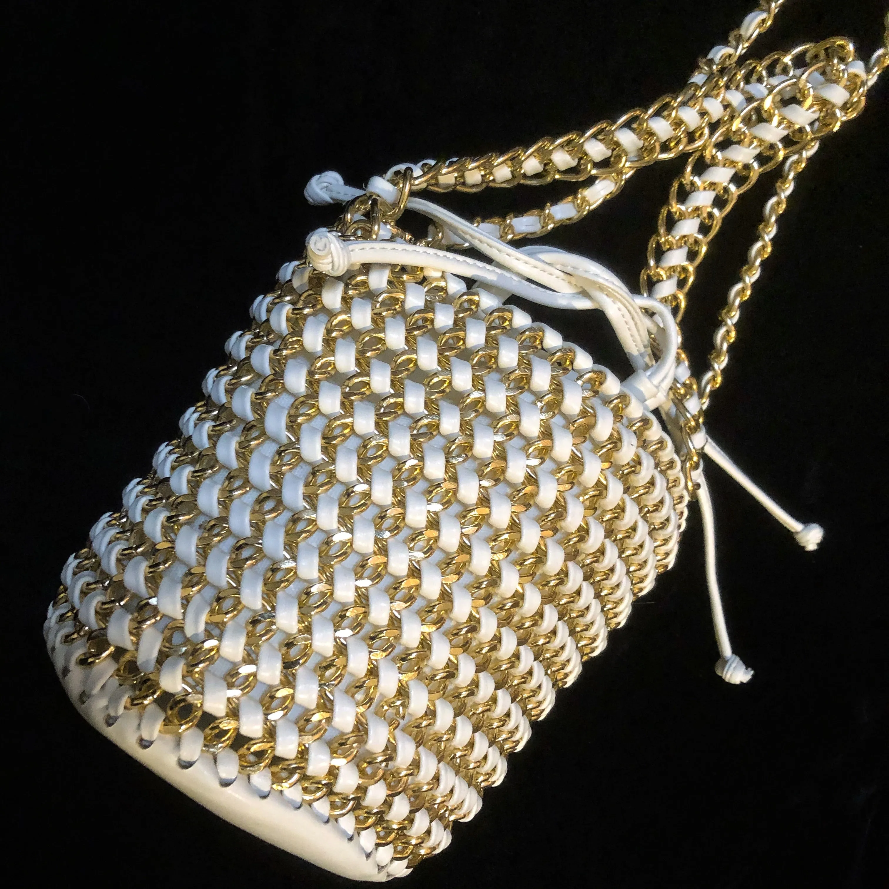 A WOVEN WHITE PVC AND GILT CHAIN BUCKET BAG